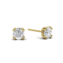 Load image into Gallery viewer, One-carat diamond stud earrings set in 18 karat yellow gold with classic four-prong claw settings, showcasing timeless elegance and brilliance.
